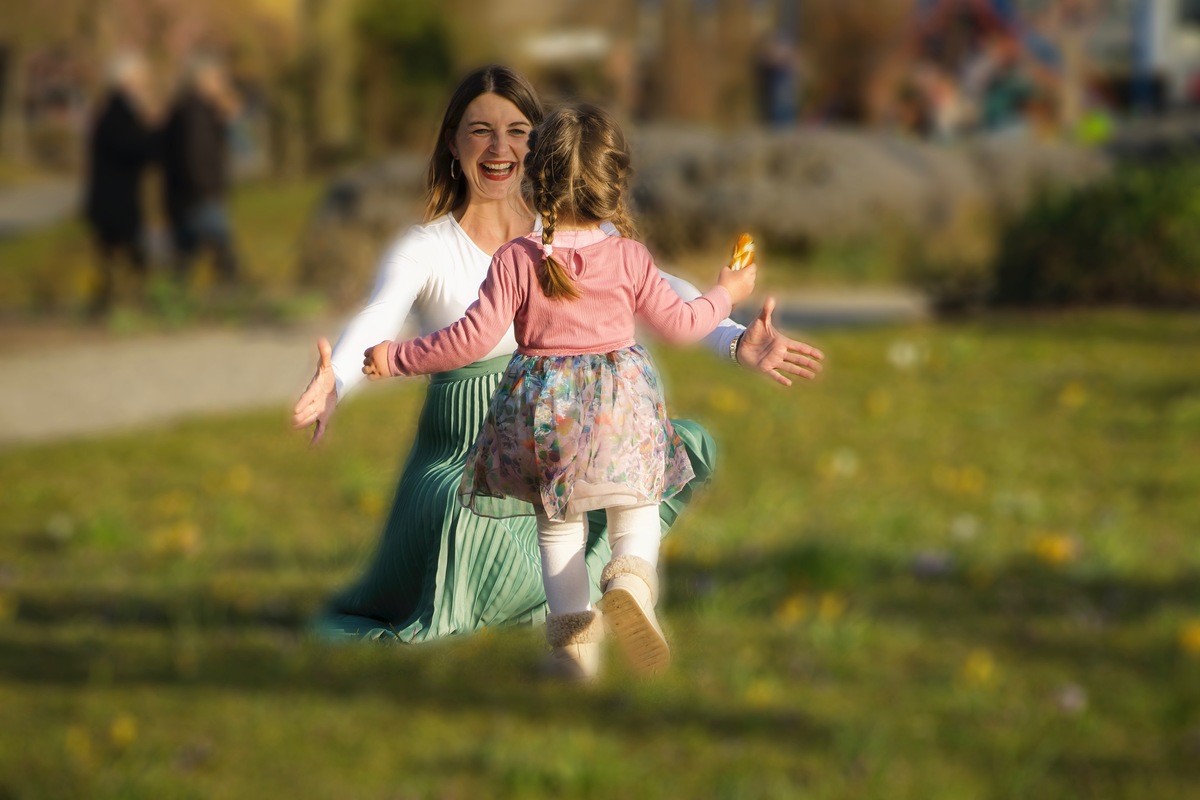 Tochter rennt auf Mama zu, die sie mit offenen Armen, Strahlegesicht und viel Liebe empfngt, emotionale Aufnahme